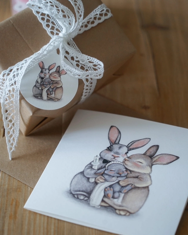 Prezent na chrzest ozdobiony papierową zawieszką Hi Little z ilustracją króliczków