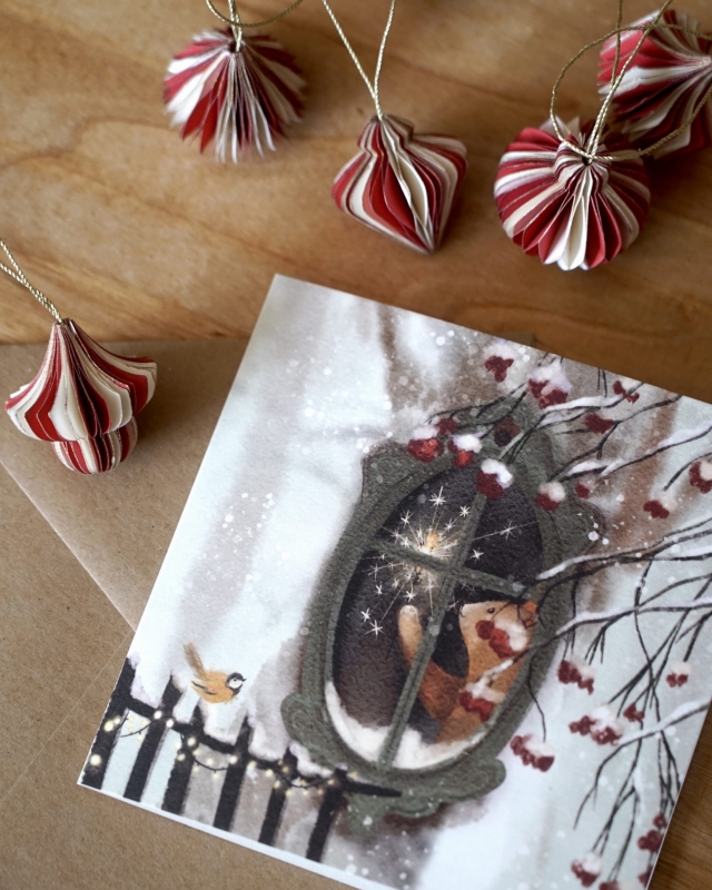 Dekoracja świąteczna ze świątecznym misiem w okienku wyczekującym pierwszej gwiazdki. Ozdoby świąteczne na stole.