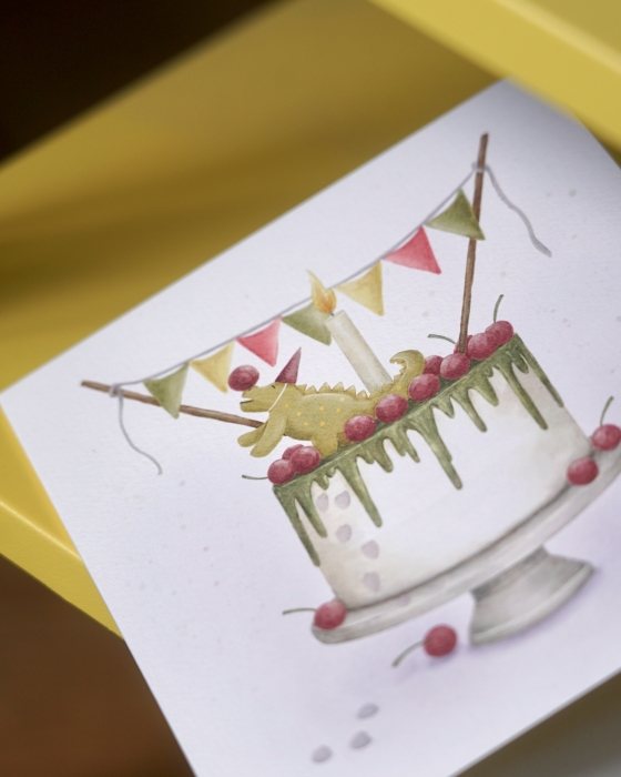 piękna kartka urodzinowa dla dziecka, które kocha dinozaury z ilustracją tortu, na którym siedzi figurka dinozaura.jpg